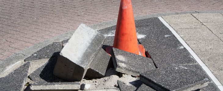 orange cone in a hole with concrete blocks broken up around it premises liability