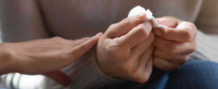 woman holding tissue while someone is consoling her wrongful death