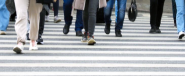 Busy city street people on zebra crossing, blured background. Pedestrian crossing through a busy street